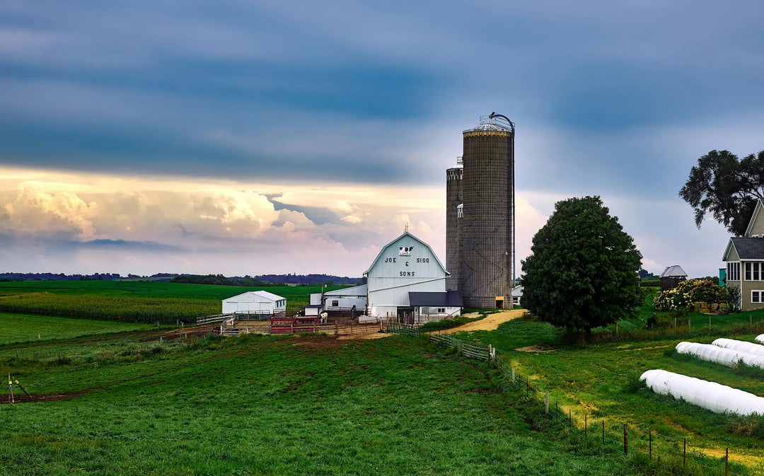 small farm with a sunset in the background
