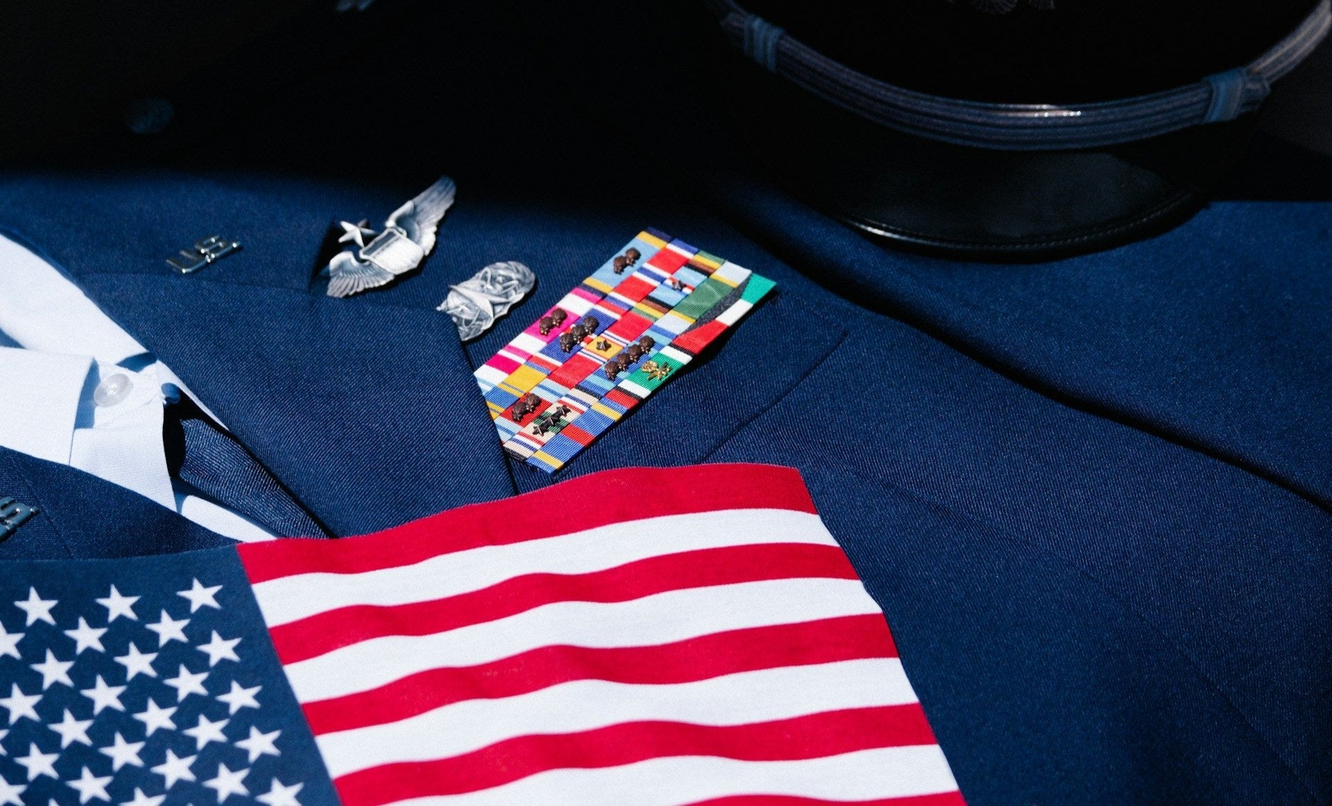 U.S. Army dress uniform with 'U.S.' collar insignia, aviation and space command badges, and multiple service patches, highlighting Earth & Tail's 10% lifetime discount for military members and veterans.